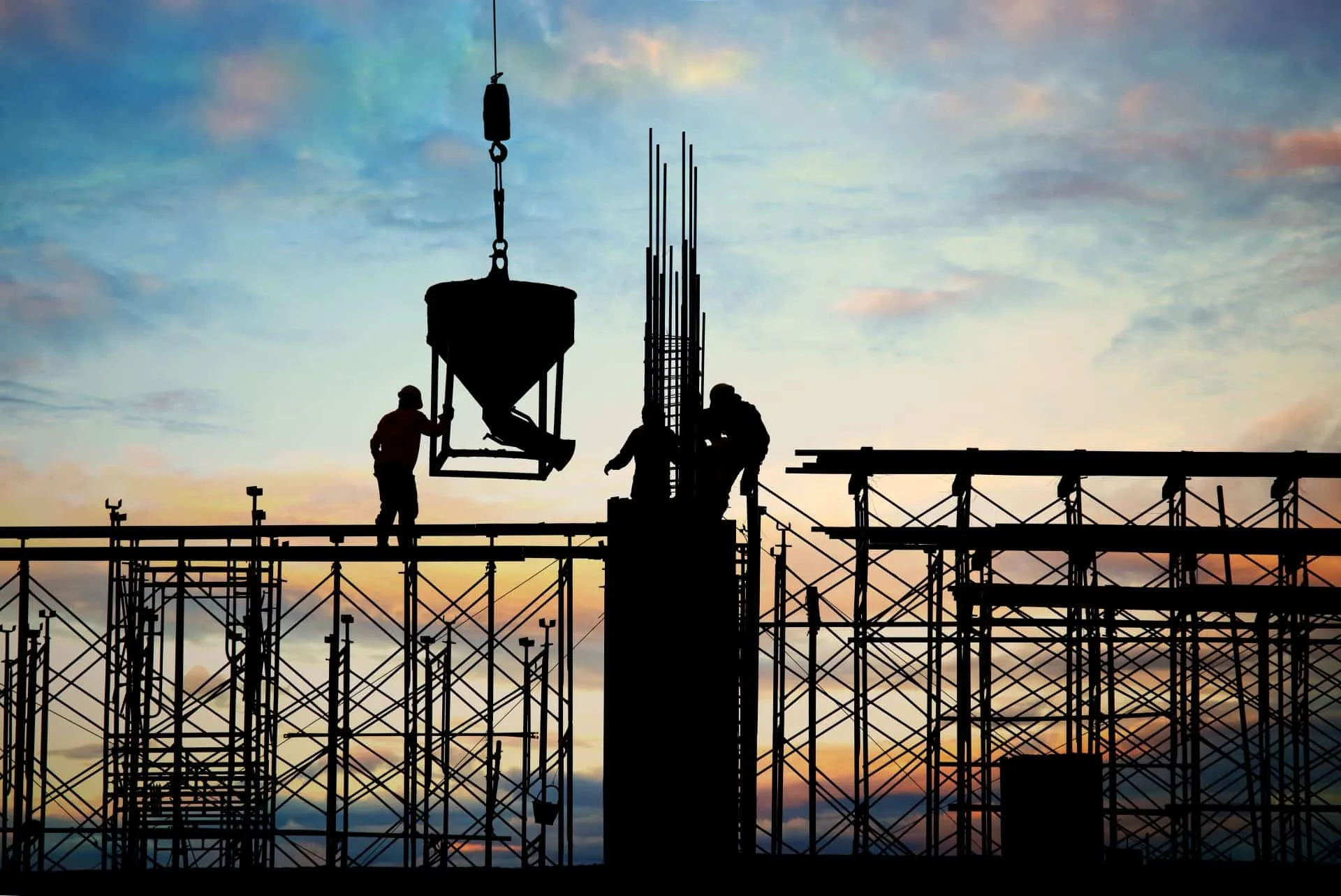 silueta-trabajadores-construccion-recuperacion-2022 Silueta de trabajadores de la construcción con casco y herramientas, representando la recuperación del sector y el crecimiento económico proyectado.