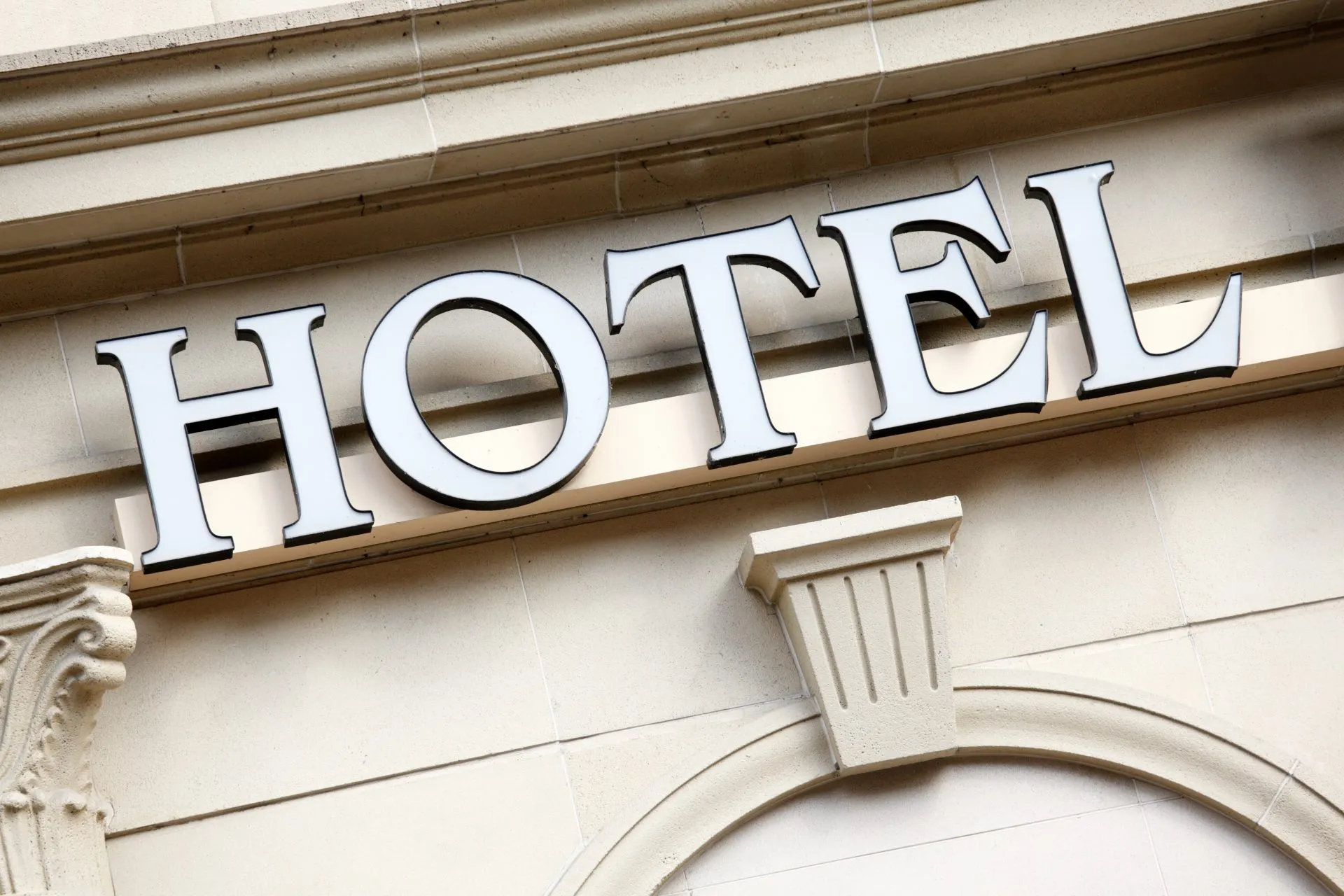 Imponente entrada de hotel moderno con columnas y vegetación, reflejando el futuro de la gestión hotelera post-pandemia