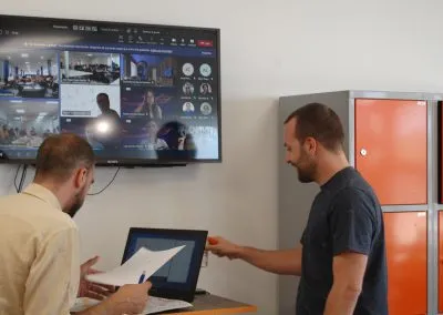Jóvenes empresarios discuten estrategias de marketing digital y desarrollo de negocio en una moderna oficina colaborativa.