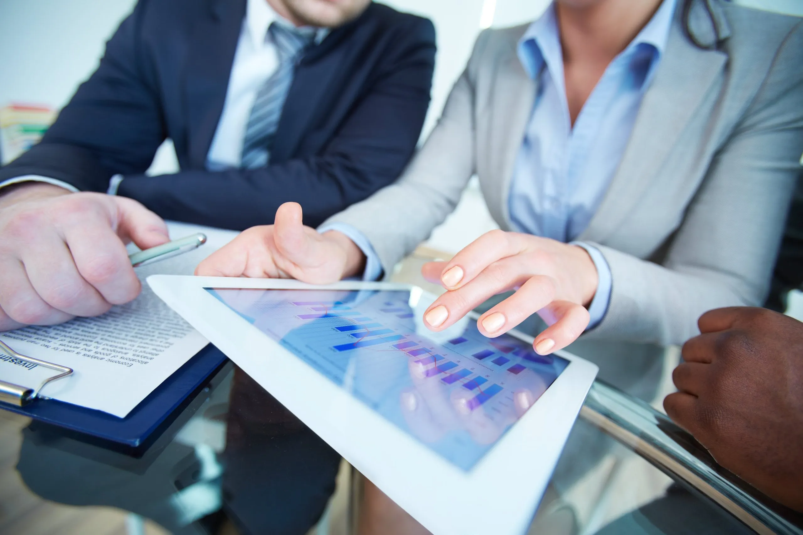empresaria-gestion-erp-consultora Empresaria profesional muestra un gráfico de rendimiento en una tableta, simbolizando la gestión eficiente de un ERP para consultoras tecnológicas.