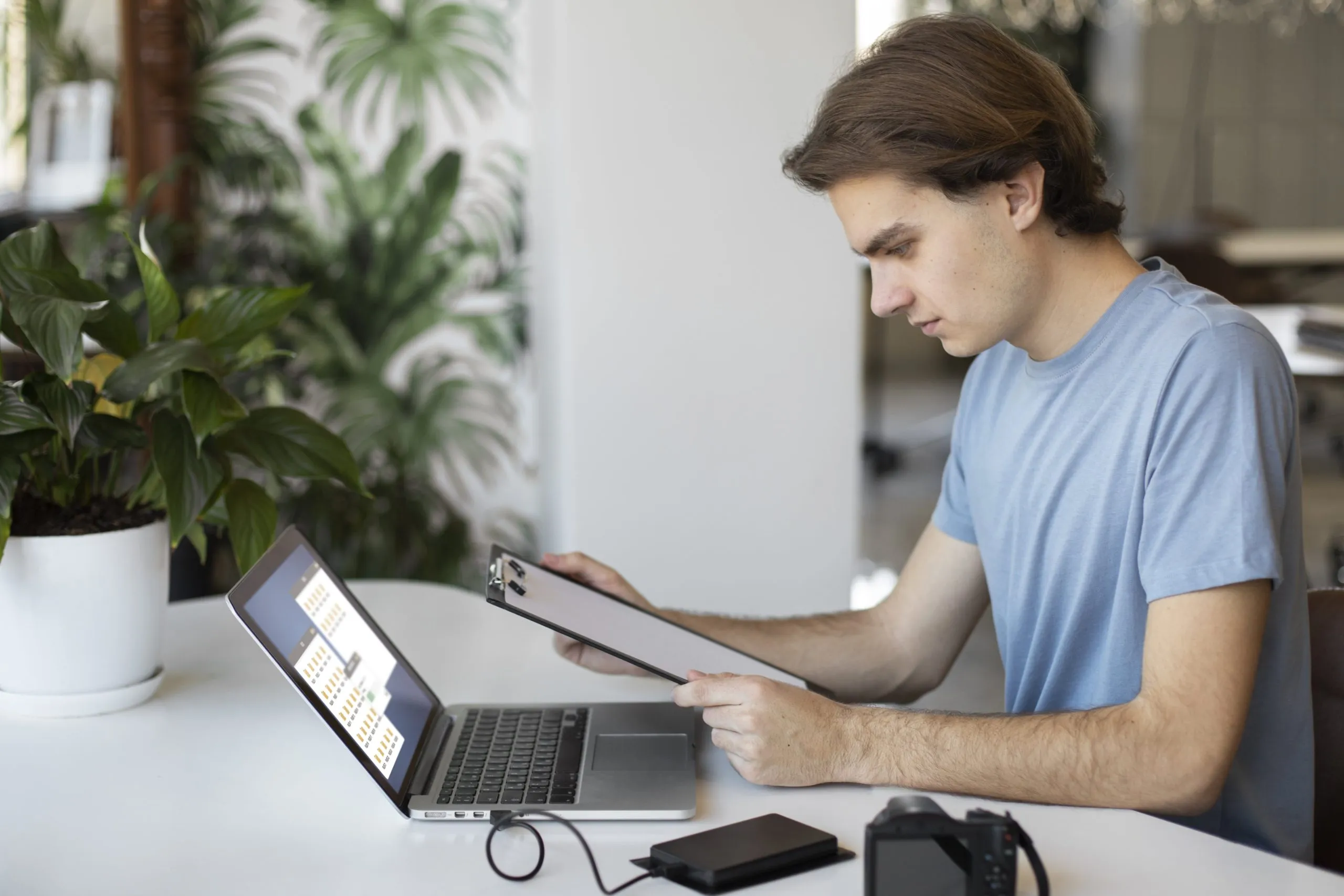 hombre-usando-almacenamiento-externo Un hombre profesional usa un disco duro externo en una oficina moderna, simbolizando la gestión eficiente de datos y tecnología empresarial.
